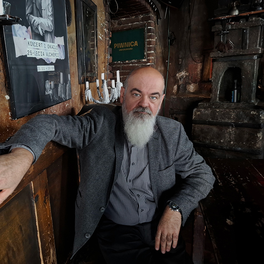 Zdjęcie Zibiego the Bearded w kawiarni – mężczyzna z brodą, okulary, drewniane wnętrze